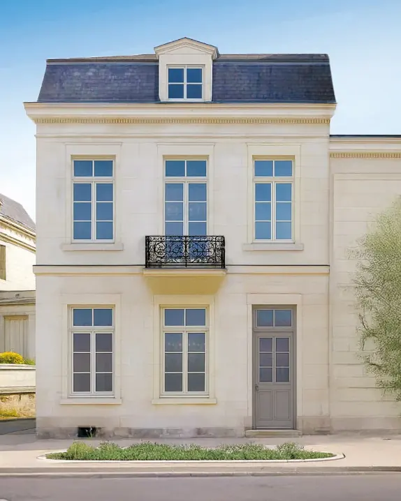 Maison bourgeoise en pierre de taille équipée de fenêtres et d'une porte d'entrée à petits bois